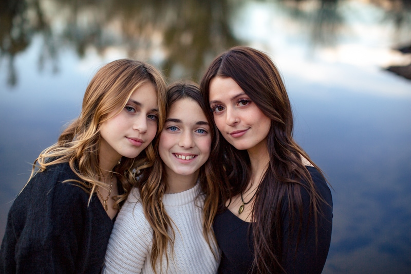Family Photographer, Three young sisters stand beside each other at the lake